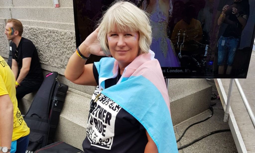Suse Green, a trans advocate, wears a trans Pride flag as she poses for the camera