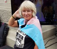 Suse Green, a trans advocate, wears a trans Pride flag as she poses for the camera