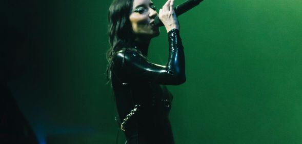 Jessica Origliasso of The Veronicas holds up a microphone as she performs on stage