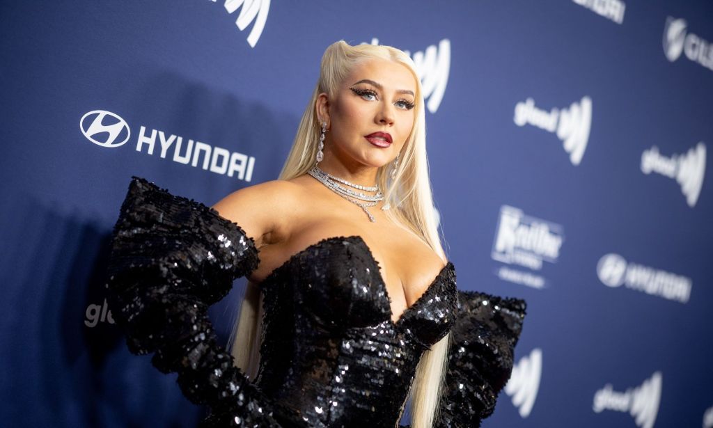 Christina Aguilera in a black sequinned dress with accentuated sleeved on the GLAAD Media Awards red carpet. 