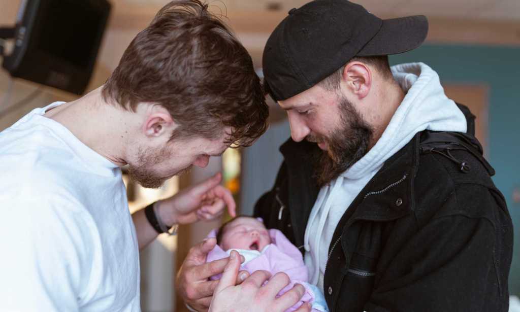 Two dads with newborn baby