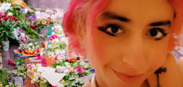 A photo of Eden Knight, a young woman with a bright pink bob and winged eyeliner, in front of flowers