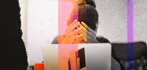 A woman is stressed behind her computer. She has her hands on her head.