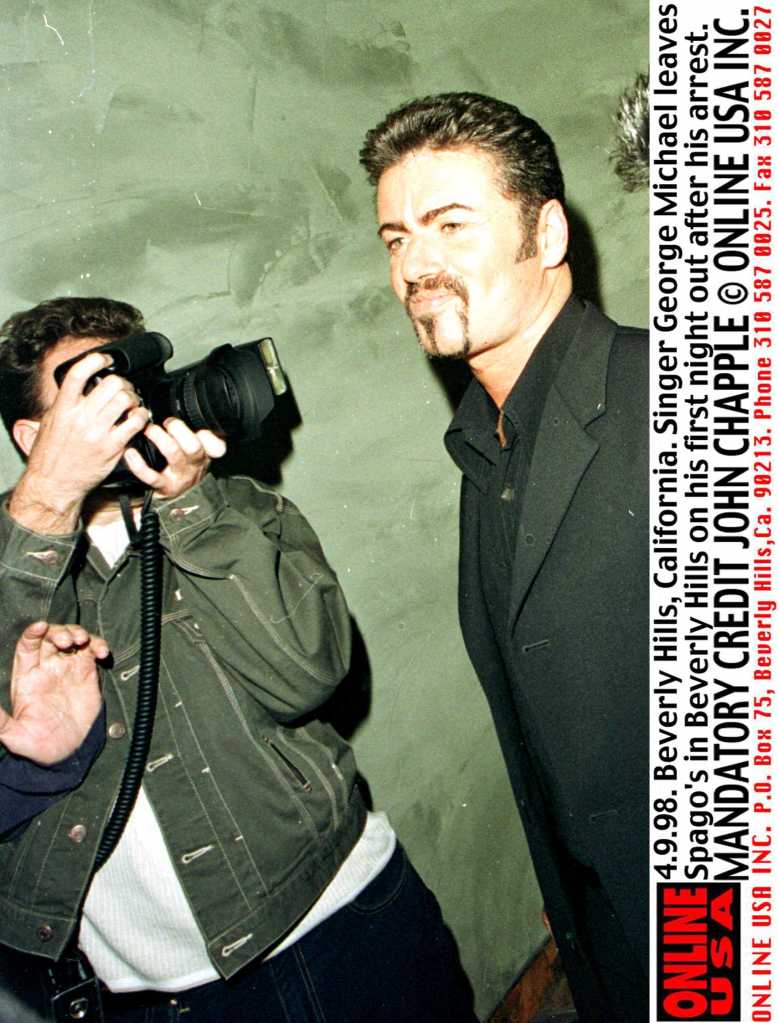 George Michael walks past a press photographer in LA.