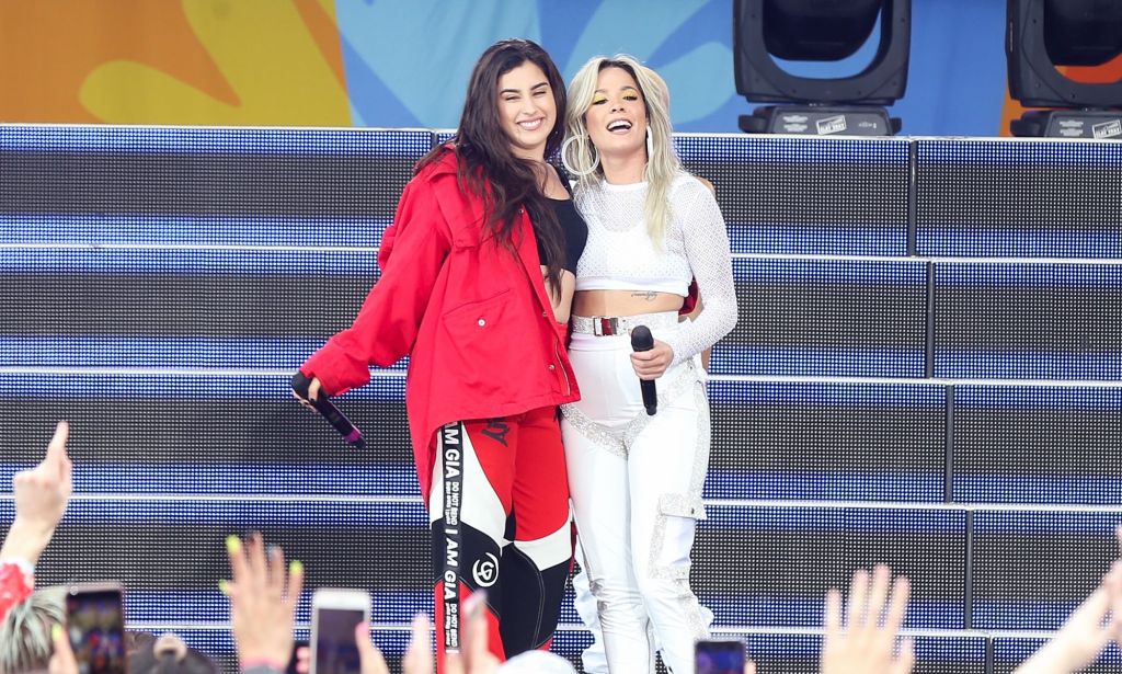 Lauren Jauregui and Halsey hold each other and smile while performing.