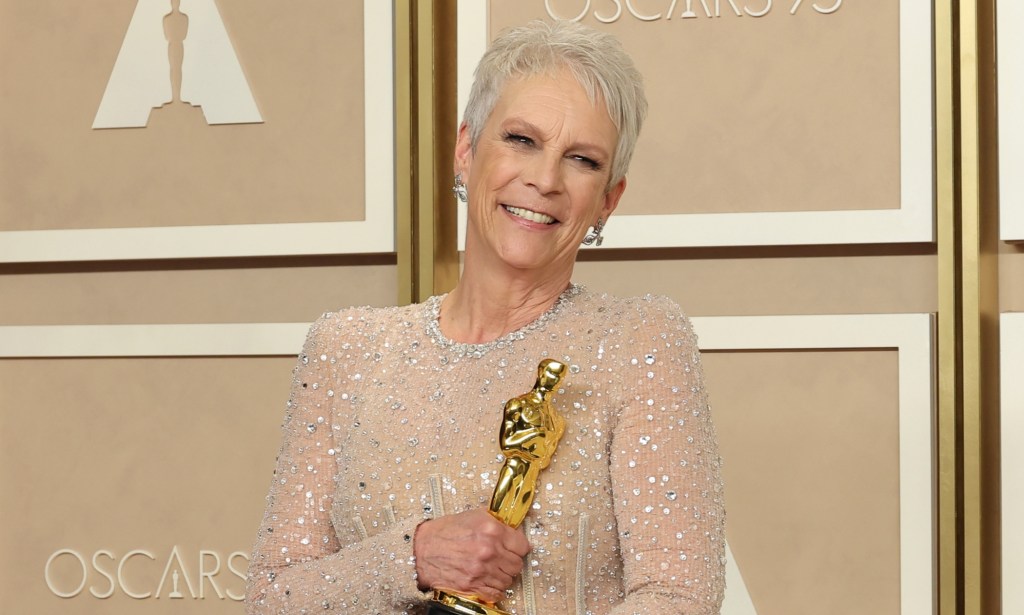Jamie Lee Curtis hold Oscar statuette smiling, after winning Best Supporting Actress for Everything Everywhere All At Once.
