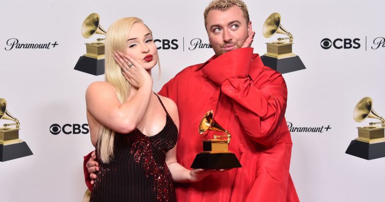 Kim Petras and Sam Smith pout and hold their Grammy award for "Unholy".
