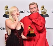 Kim Petras and Sam Smith pout and hold their Grammy award for "Unholy".