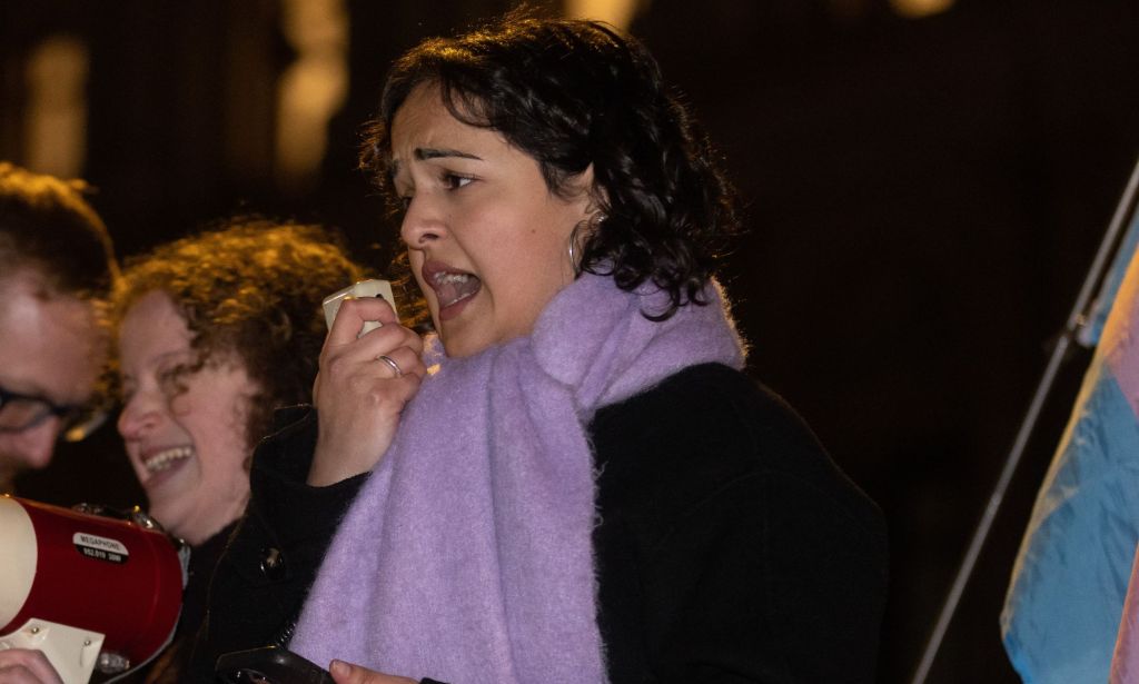 Nadia Whittome speaking into a microphone during a protest.
