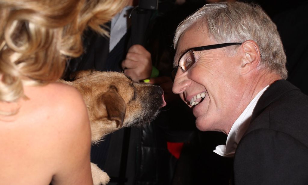 Paul O'Grady smiling at a dog.