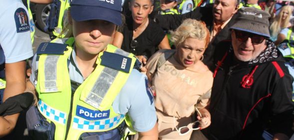 Posie Parker being escorted from her rally.