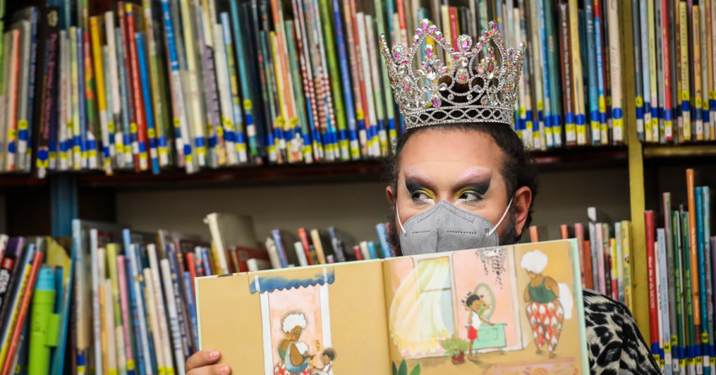 A photo of drag queen Just JP reading stories to children during a Drag Story Hour at Chelsea Public Library in the United States.