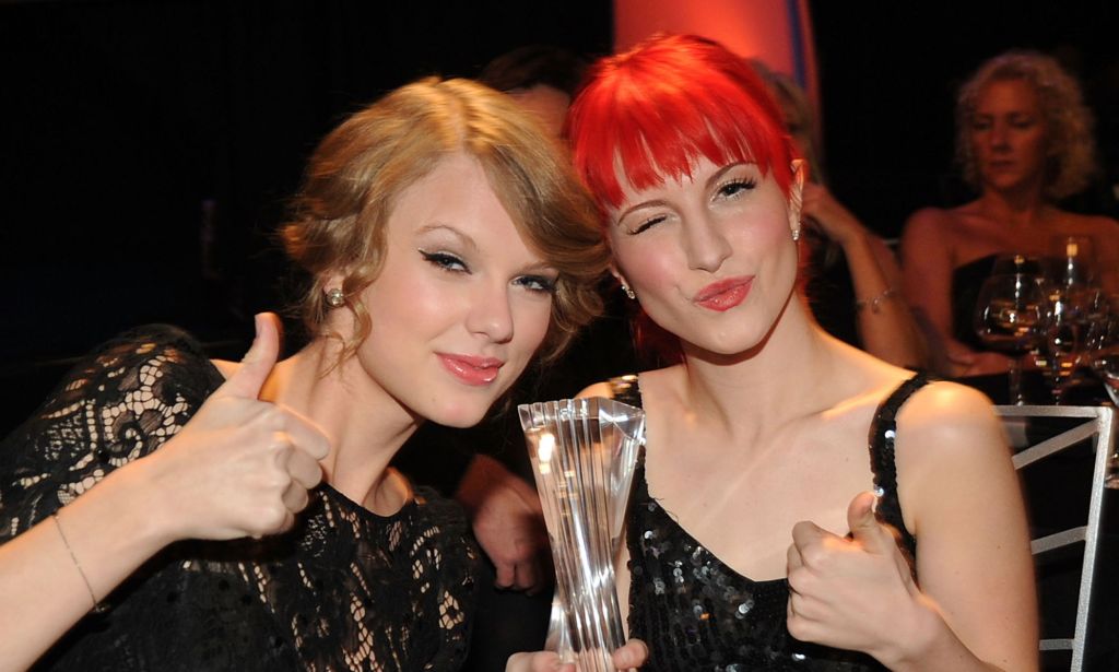 Taylor Swift and Hayley Williams smiling at the camera and put their thumbs up.
