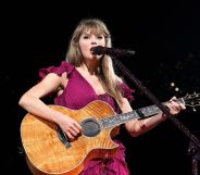 Taylor Swift in a dark pink gown singing with her guitar on the Eras Tour.