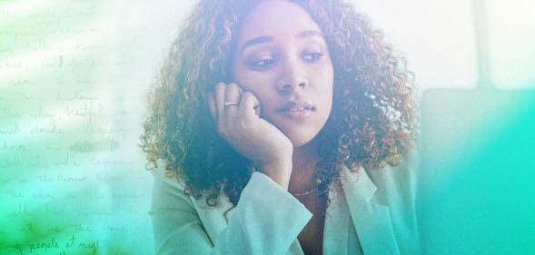 A woman looks stressed with her head resting on her hand.