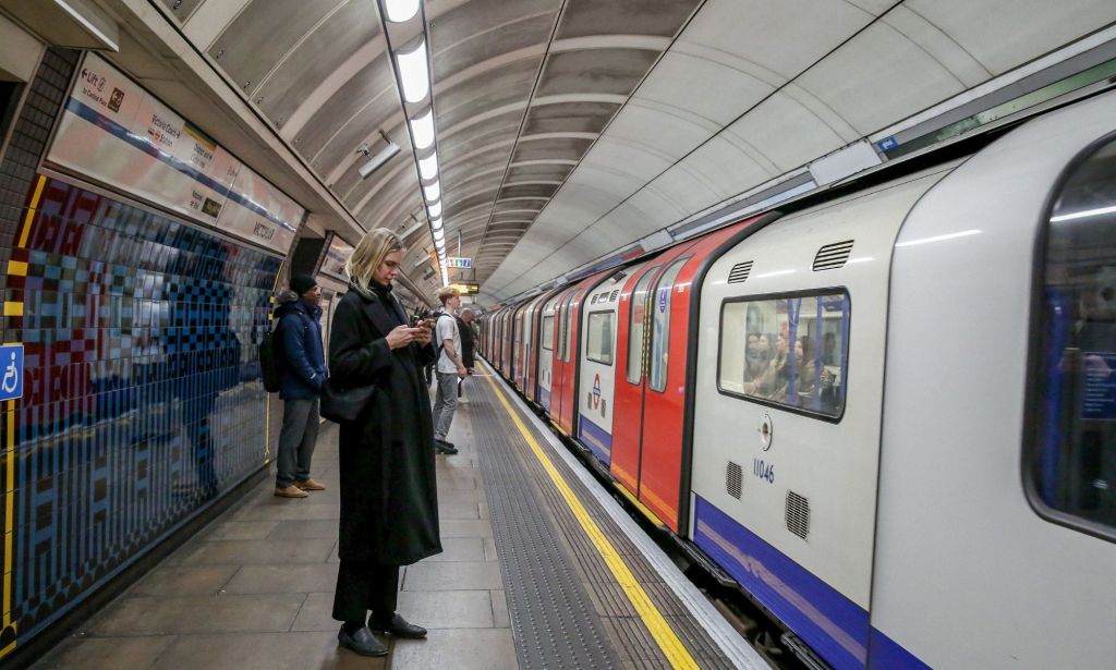 Members of the public wait for a London Underground train.