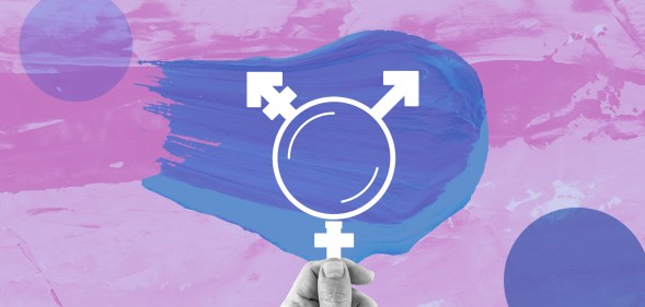 A hand holding up a microscope in the shape of the trans symbol