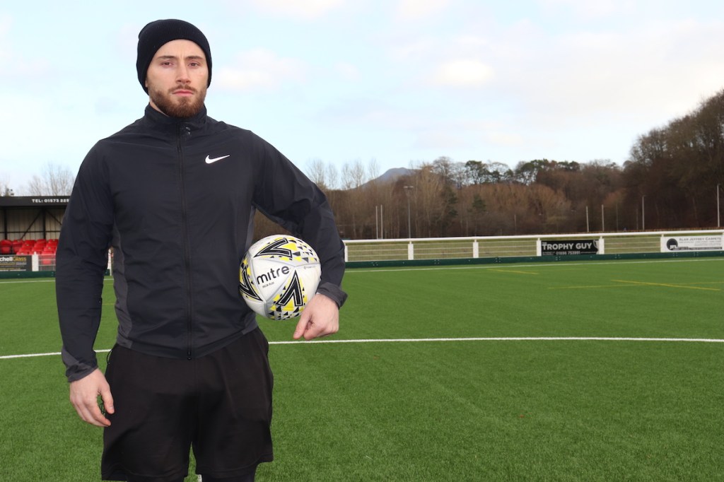 Zander Murray in a still from his new BBC documentary. He is pictured on a pitch holding a football.
