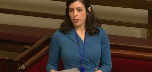 Australian MP Moira Deeming wears a blue dress as she speaks before her fellow lawmakers.