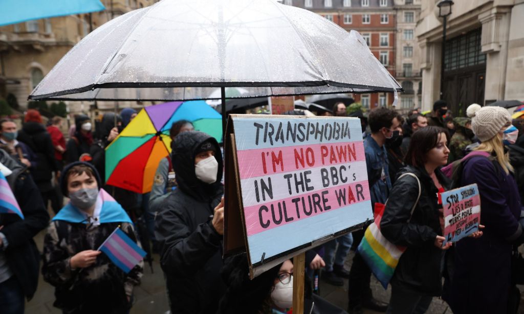 Demonstrator holds placard reading "Transphobia. I'm no pawn in the BBC's culture war" during protest outside the BBC's office in London over anti-trans article