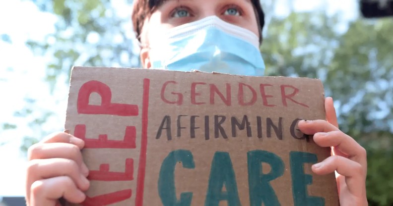 A person holds up a sign reading 'Keep gender-affirming care' during a demonstration in support of healthcare for trans youth