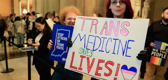 A person holds up a sign reading 'Trans medicine saves lives' during a protest in support of trans and non-binary people in the Indiana state capitol