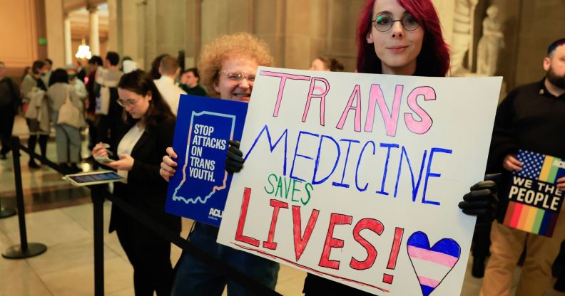 A person holds up a sign reading 'Trans medicine saves lives' during a protest in support of trans and non-binary people in the Indiana state capitol