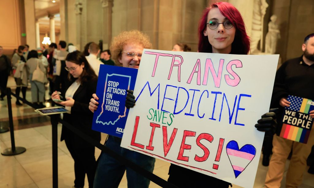 A person holds up a sign reading 'Trans medicine saves lives' during a protest in support of trans and non-binary people in the Indiana state capitol