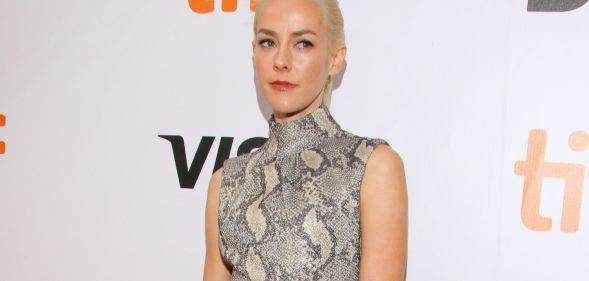 Actor Jena Malone wears a black, white and grey snake skin patterned outfit as she poses for the camera