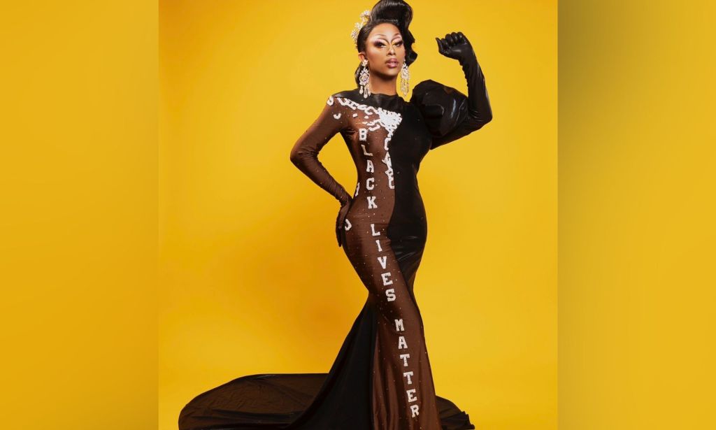 Texas-based drag queen Kylee Ohara Fatale poses with one arm raised up while wearing a black and brown dress with the words 'Black Lives Matter' written on it