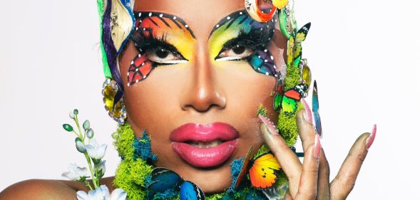 Texas-based drag queen Kylee Ohara Fatale poses for the camera while wears rainbow butter-fly themed makeup with butterfly props and flora in her makeup