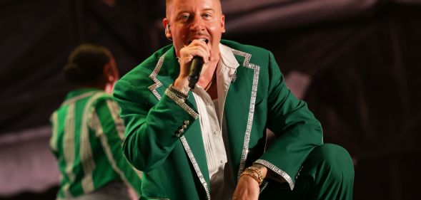 American rapper Macklemore wears a green and white outfit as he performs on stage