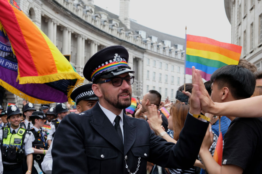 A member of the Metropolitan LGBT Police Network greets participants during London Pride. 