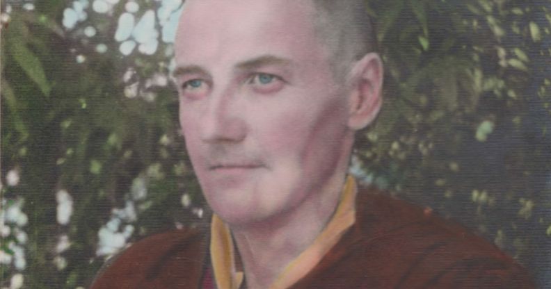 A picture of trans trailblazer Michael Dillon wearing red and yellow coloured Buddhist monk robes