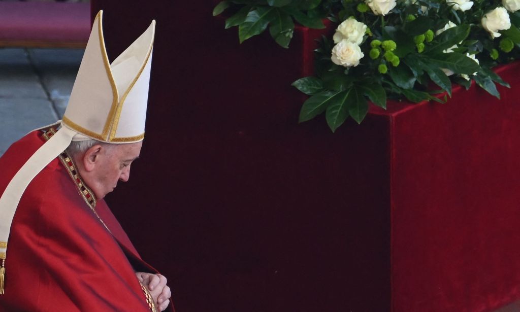 Pope Francis wears red garments and a white cap as he leads the funeral for Pope Benedict, his predecessor