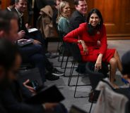 Suella Braverman sitting in a chair, laughing with people surrounding her