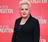 Trans actor and comedian Suzy Eddie Izzard wears a dark shirt and dark jacket as she smiles for the camera at an event
