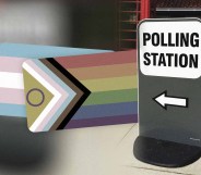 A polling station sign with the trans and Pride flags