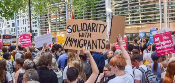 A protester holds a 'Solidarity with immigrants' placard during a demonstration.