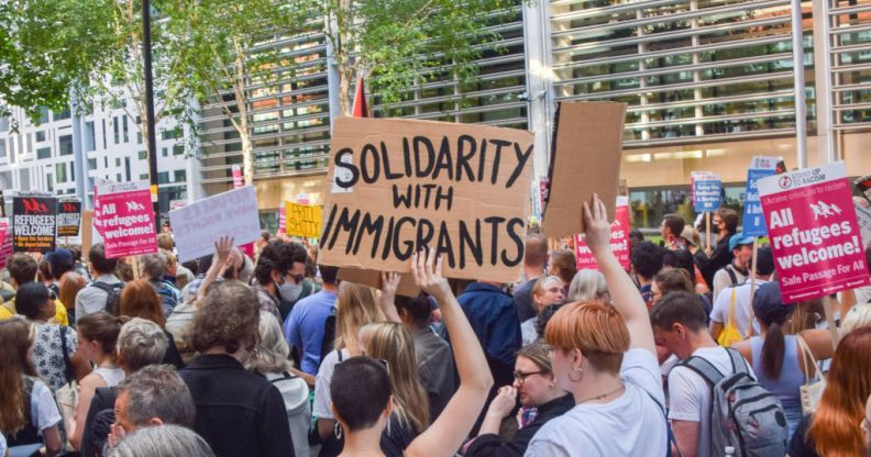 A protester holds a 'Solidarity with immigrants' placard during a demonstration.