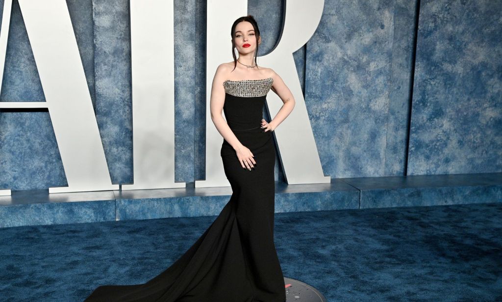 Dove Cameron in a black dress with a train at Vanity Fair's Oscars after party.