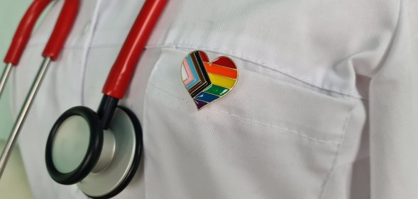 Silhouette of doctor in white coat with stethoscope and LGBT badge on pocket concept