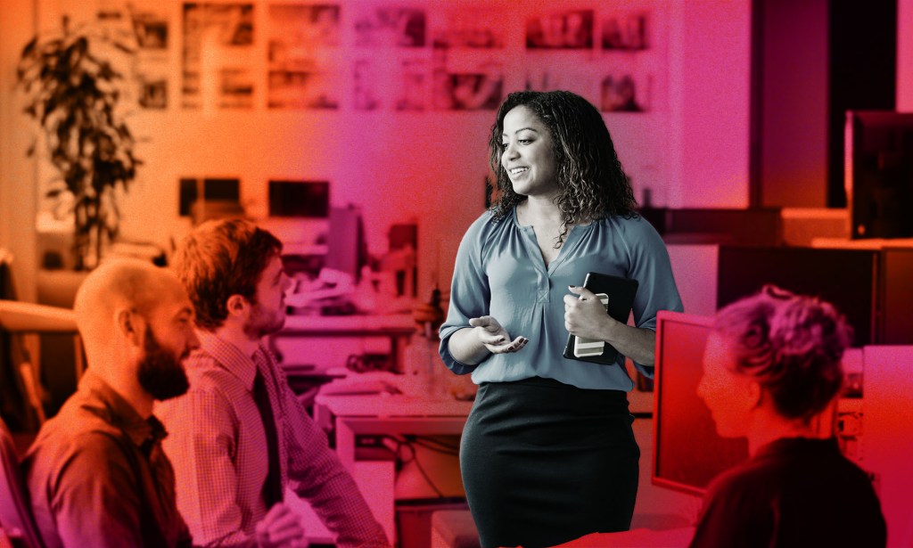 This is a stylised image of a woman speaking to her colleagues at work. Her image is emphasized over a red an orange background