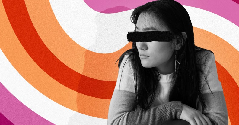 Composite image of woman with black-out paint over her eyes against the lesbian flag