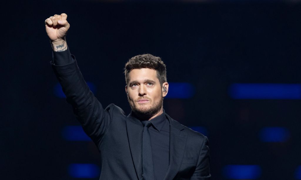 Michael Buble performs, holding his fist and microphone in the air.