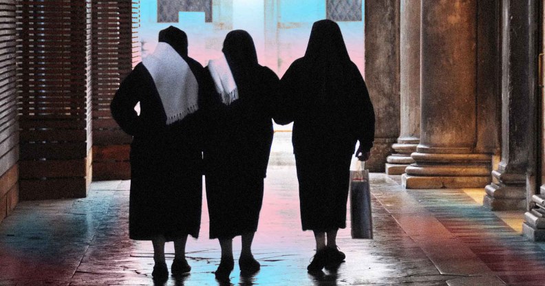 Image shows a group of nuns walking with their backs to the camera, in front of a backdrop of the transgender flag