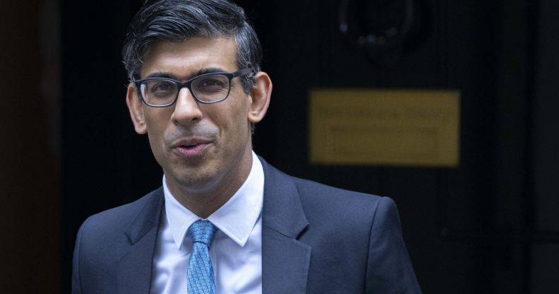 Rishi Sunak walking down a street.