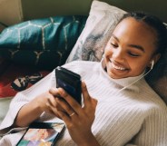 Stock image of a teenager using her mobile phone and smiling