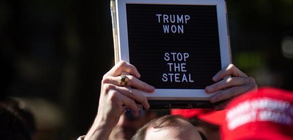 A Trump supporter holds a sign that says "Trump Won" at the Stop the Steal rally at the Georgia Capitol Building on Wednesday 18 November, 2020