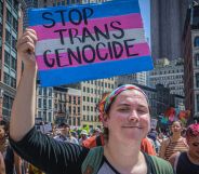 Trans protestor holding up a sign that reads "stop trans genocide"